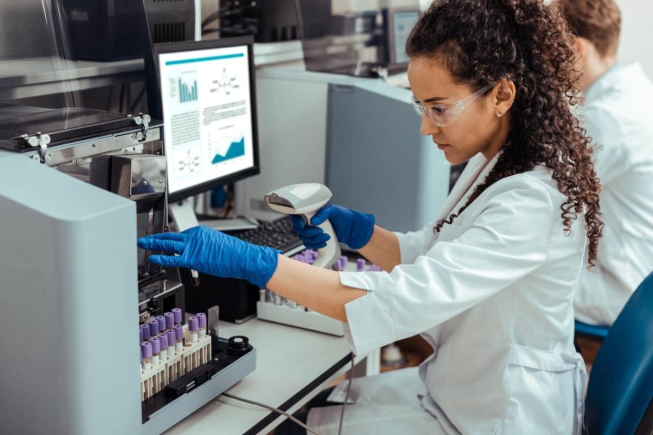Female medical professional in a lab looking at a test tube