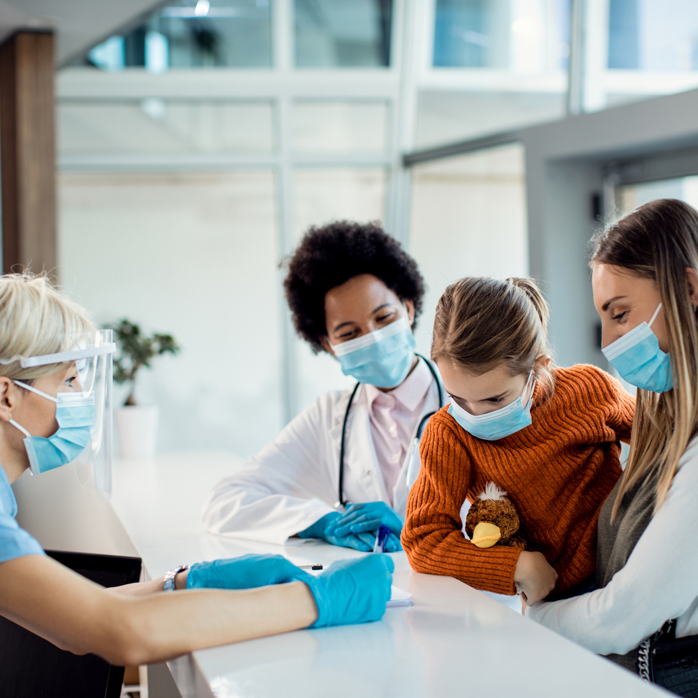 Mother and daughter checking in at medical clinic during coronavirus pandemic