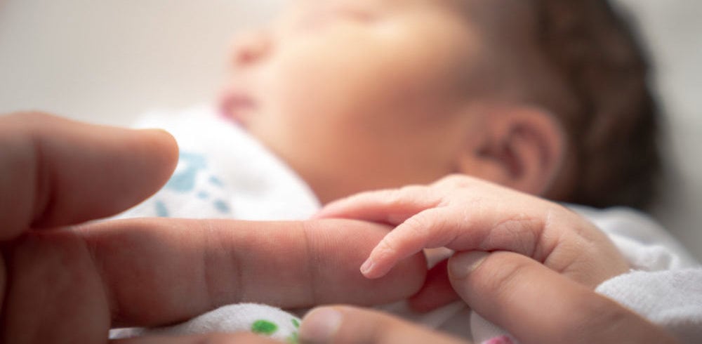 William Russell - International Maternity insurance - banner newborn holding parents finger